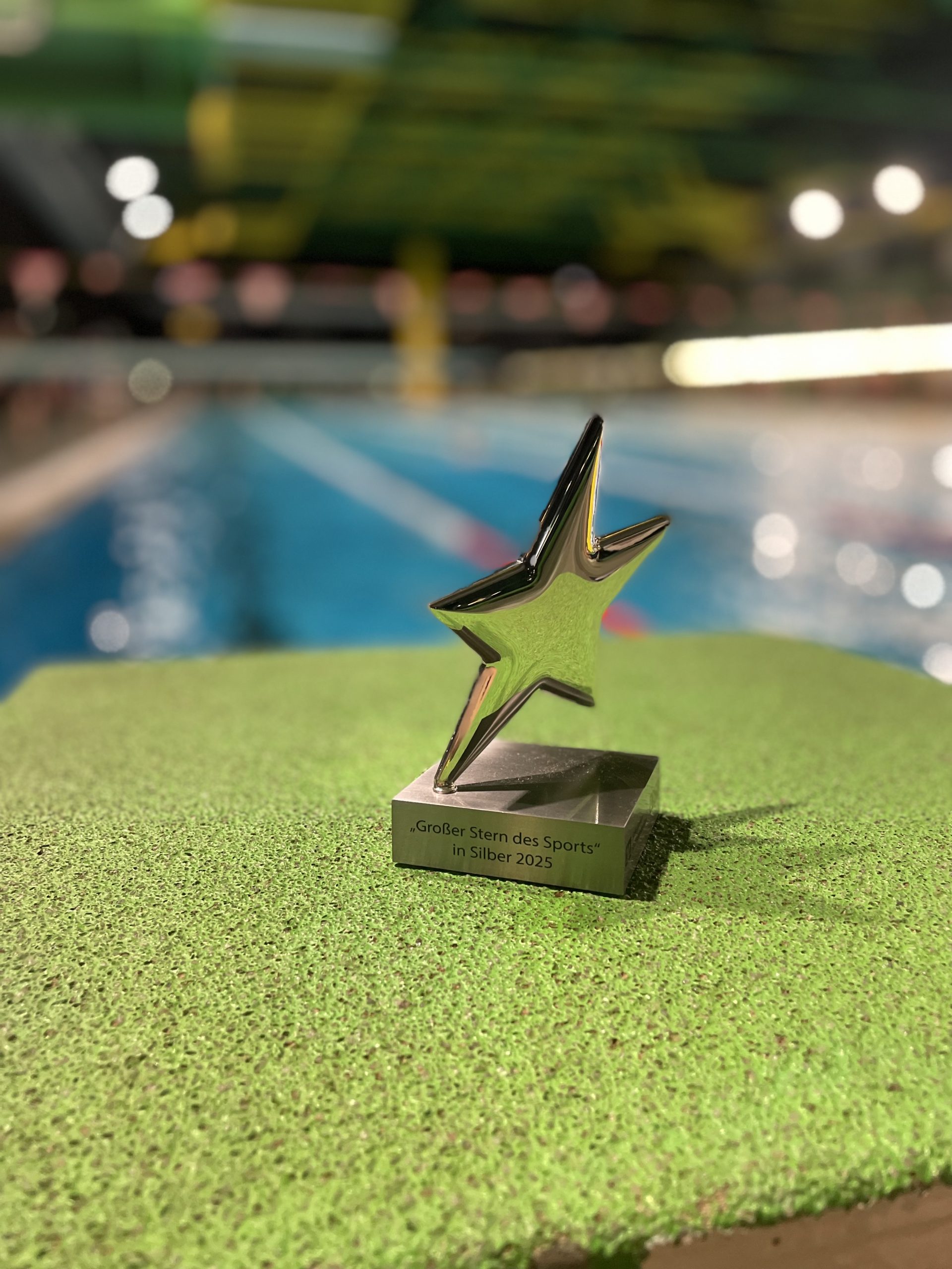 Silberner Stern des Sports auf dem Startblock im Schwimmbad